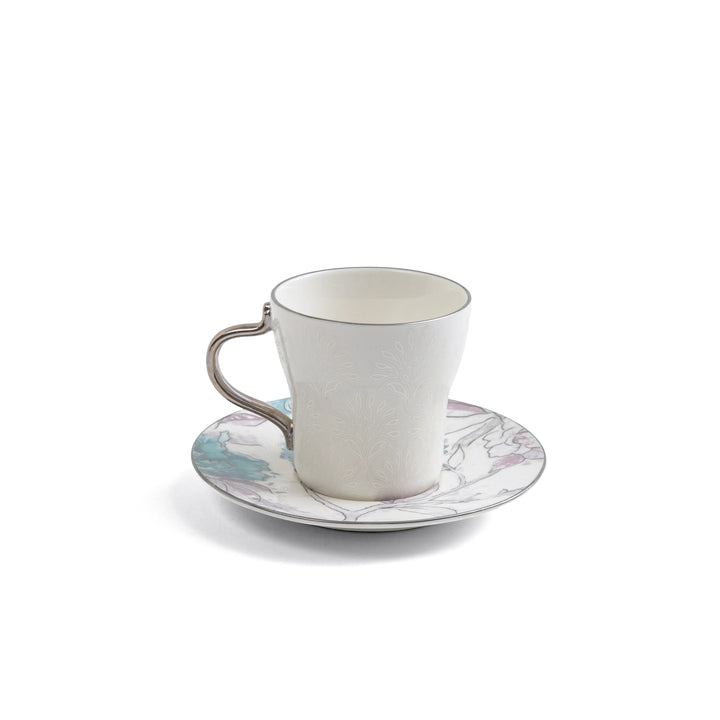 White ceramic cup and saucer with floral design on a white background
