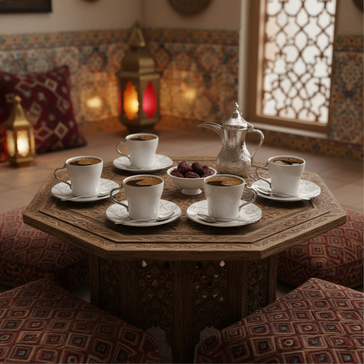 Café setting with cups of coffee on a wooden table, surrounded by decorative lanterns and cushions.