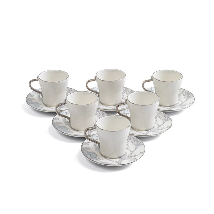 Set of six white ceramic cups with saucers on a white background