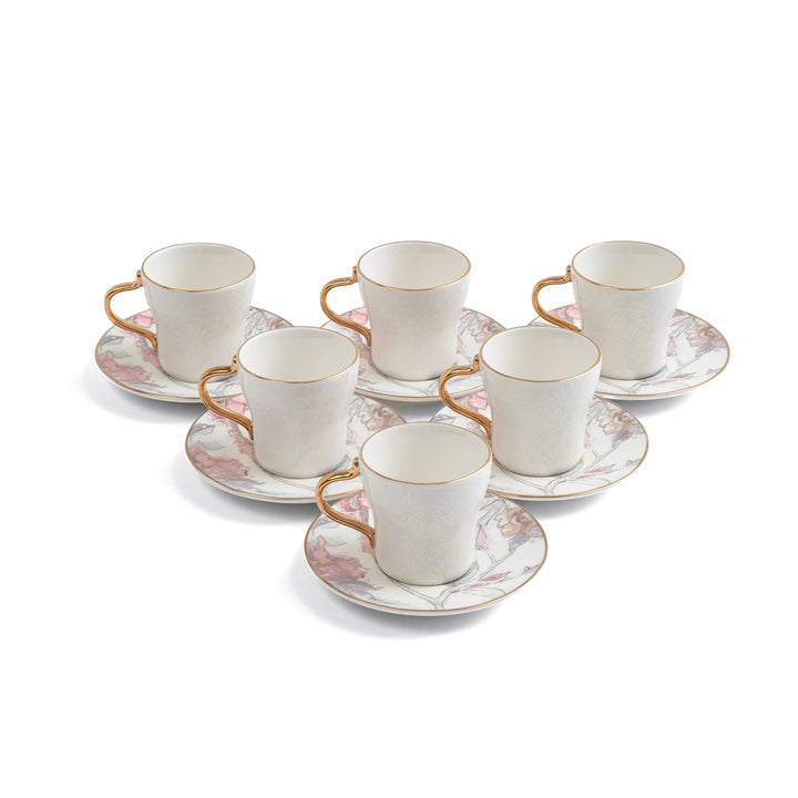 Set of six white ceramic cups with gold handles and saucers on a white background
