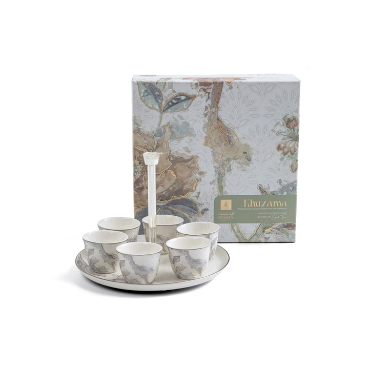 Set of ceramic tea cups and saucers with a decorative box on a white background