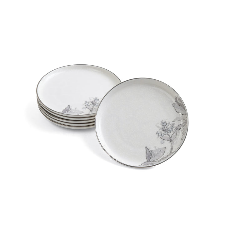 Set of white ceramic plates with floral patterns on a white background