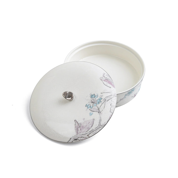 Round ceramic container with floral design on a white background