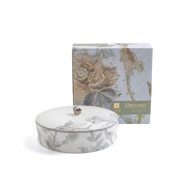 Decorative ceramic dish with floral patterns and matching box on a white background