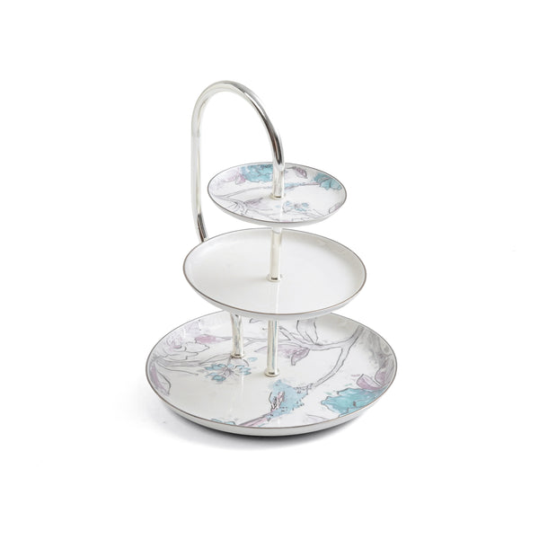 Three-tiered ceramic cake stand with floral design on a white background