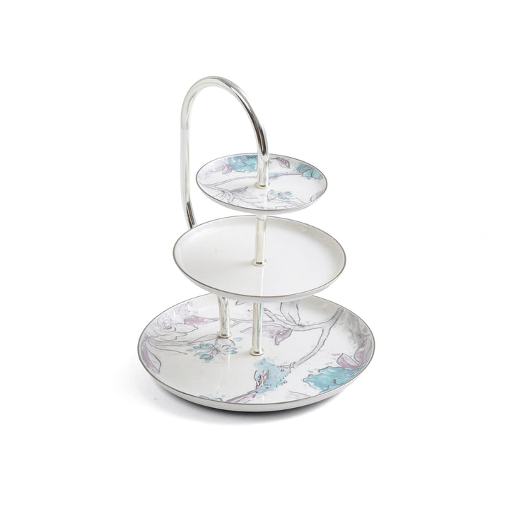 Three-tiered ceramic cake stand with floral design on a white background