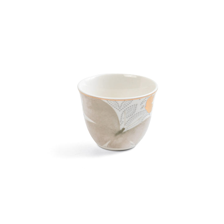 Ceramic cup with a leaf pattern on a white background