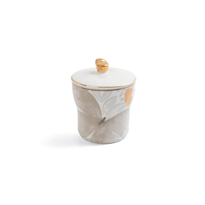 Decorative jar with a gold lid on a white background