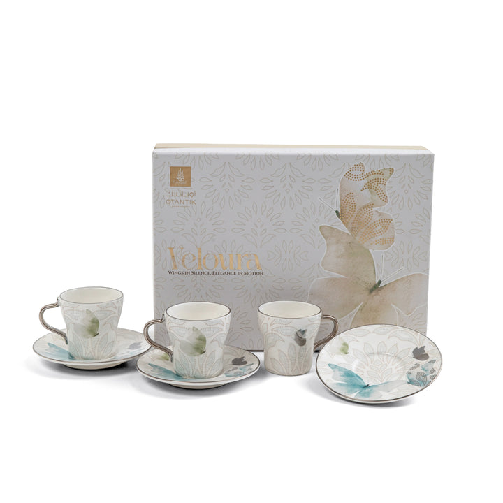 Ceramic tea set with floral design on saucers and cups, displayed in front of a branded box.