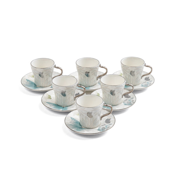 Set of ceramic cups and saucers with floral patterns on a white background