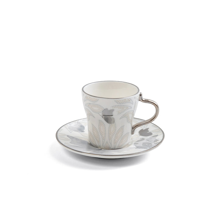 Ceramic cup and saucer set with floral pattern on a white background