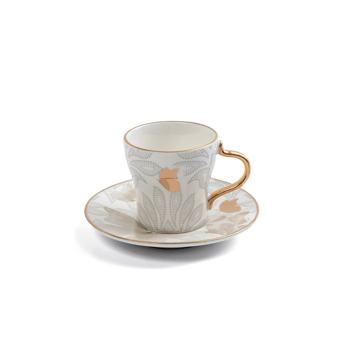 Ceramic cup and saucer with floral design on a white background