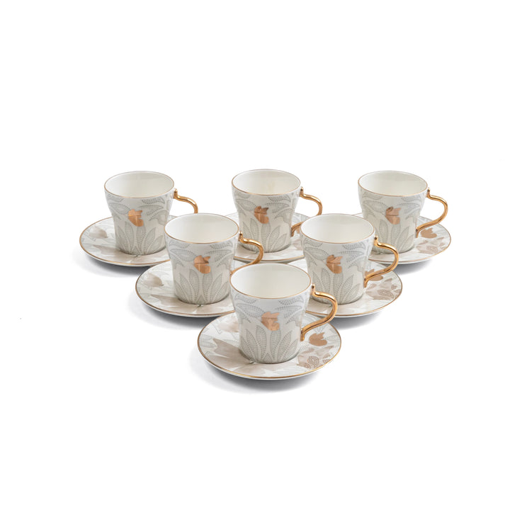 Set of six ceramic cups and saucers with gold accents on a white background