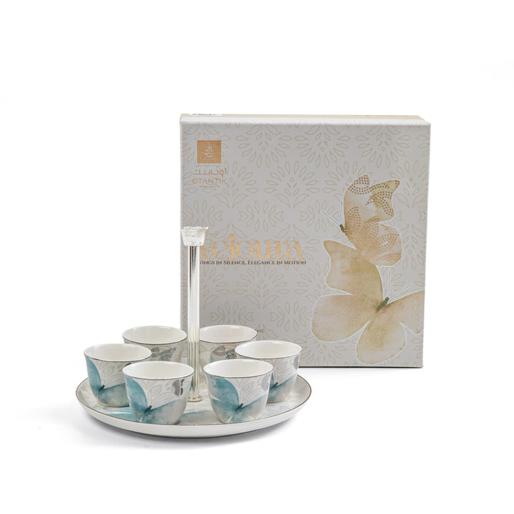 Set of ceramic cups with a decorative tray in front of a branded box on a white background