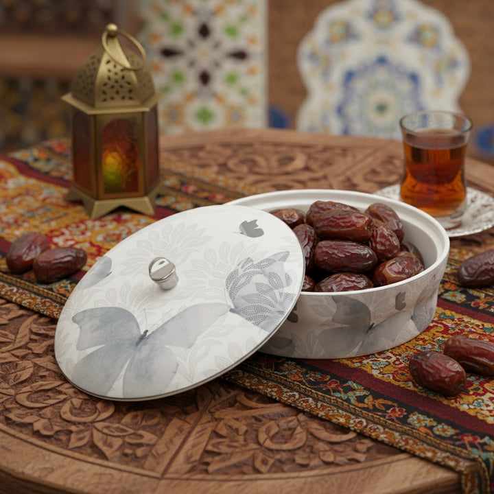 Bowl of dates with a tea cup on a decorative table with lantern and tiles in the background