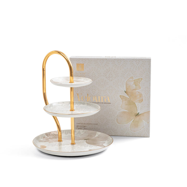 Three-tiered ceramic tray with gold accents in front of a 'Jovana' branded box on a white background