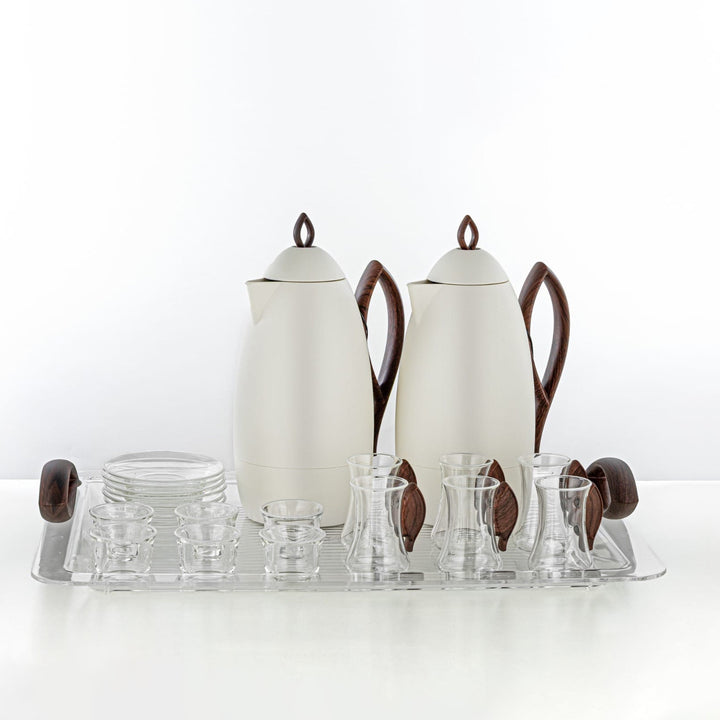 Tea set with two white teapots, a tray, and glass cups on a white background
