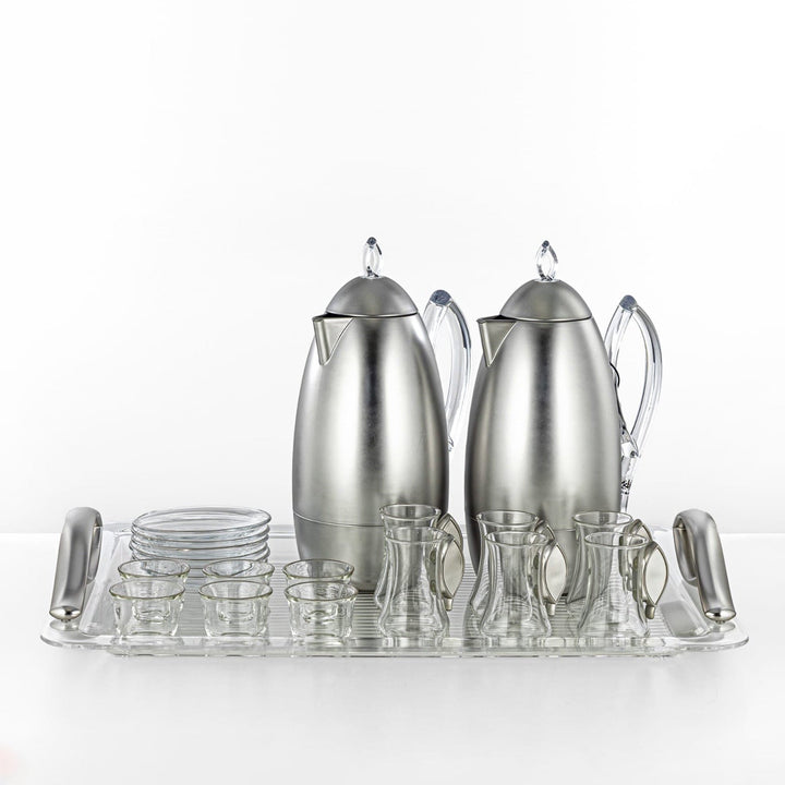 Stainless steel coffee set with teapot, carafe, and glasses on a white background
