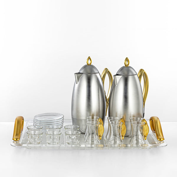 Silver and gold coffee set with serving tray on a white background