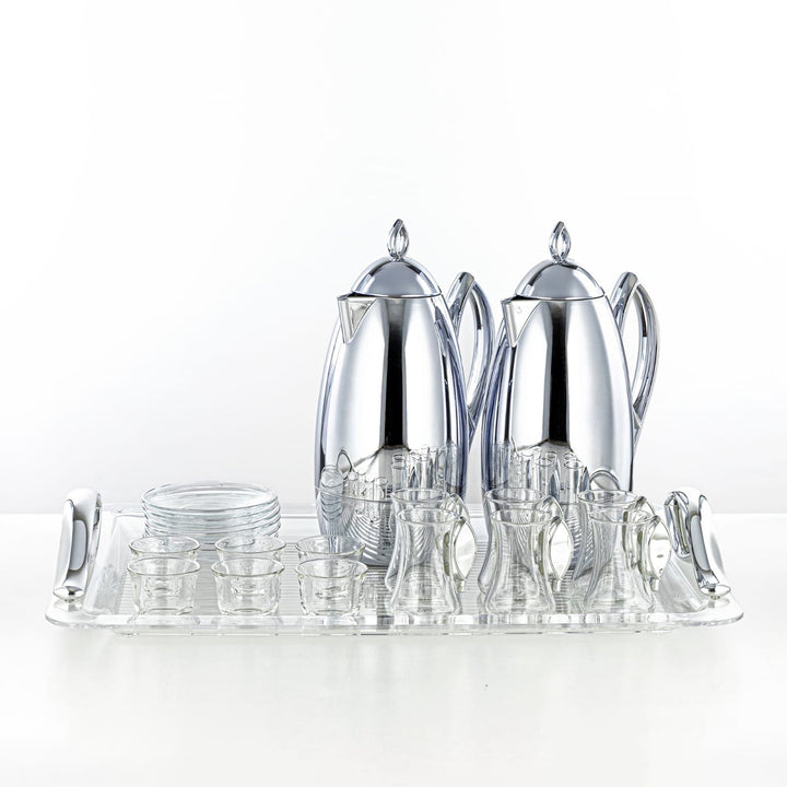 Silver tea set with teapot, coffee pot, and glasses on a white background