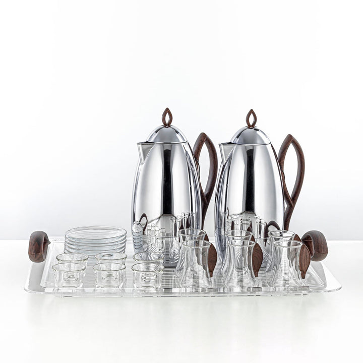 Silver tea set with glass cups on a white background