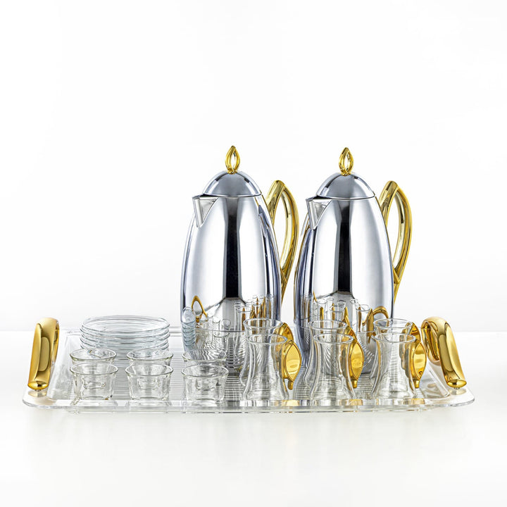 Silver and gold tea set with glasses on a white background