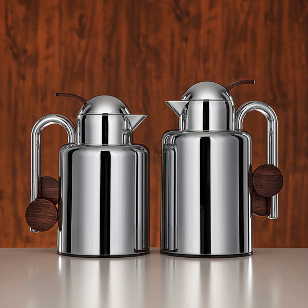 Two silver milk jugs with wooden handles on a white background