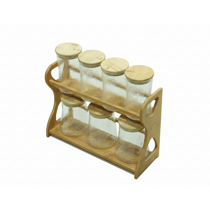 Set of glass jars with wooden lids on a wooden stand against a white background