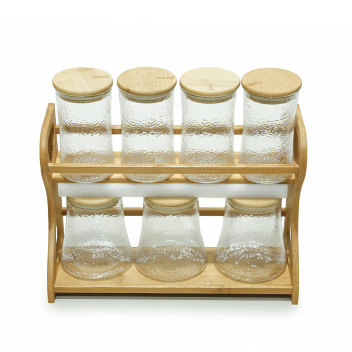 Set of glass jars with wooden lids on a wooden stand against a white background