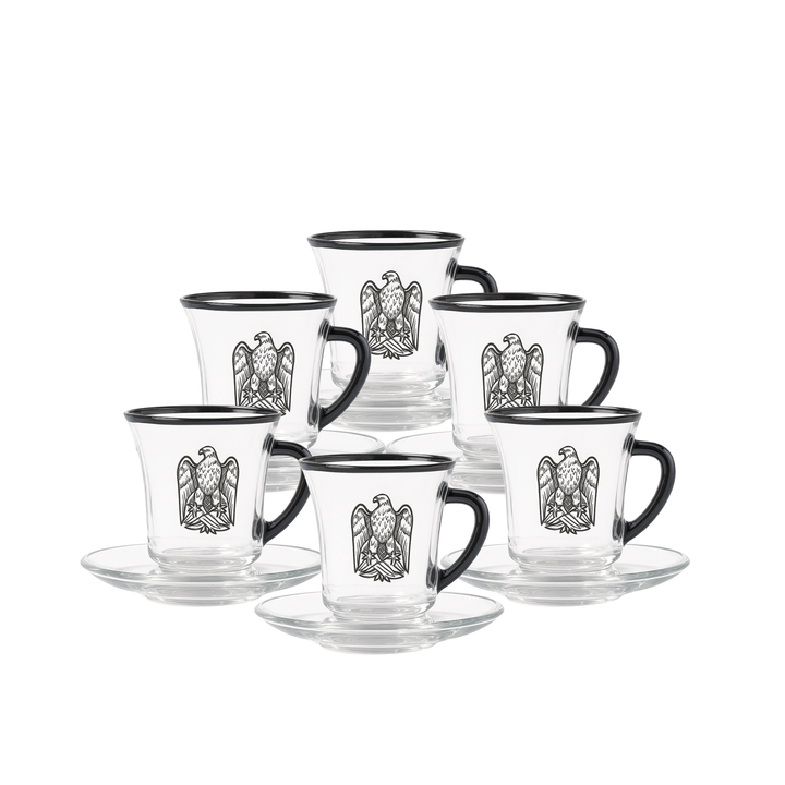 Set of glass mugs with black handles and decorative eagle emblem on a white background