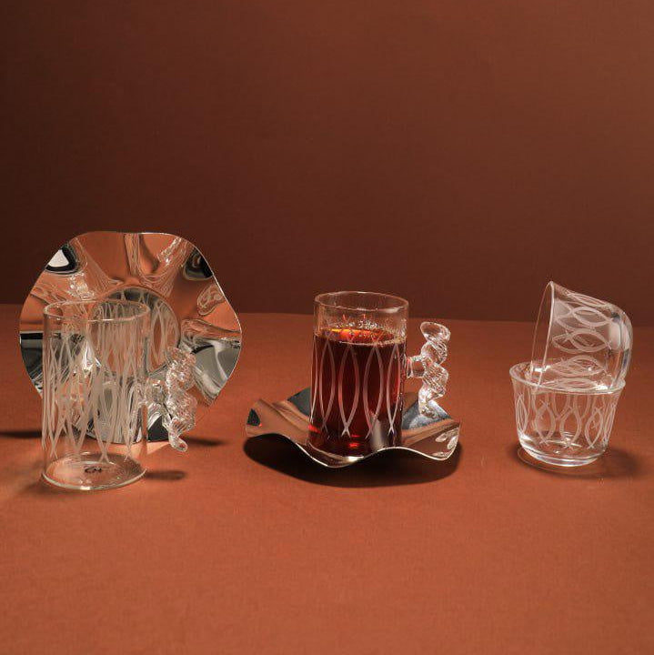 Set of crystal glasses and a plate on a brown surface with a brown background