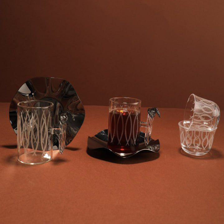 Set of glassware including a bowl, cups, and a tray on a brown background