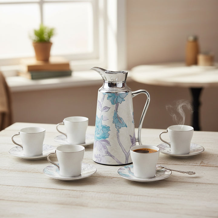 Coffee set with floral-patterned carafe and cups on a wooden table.
