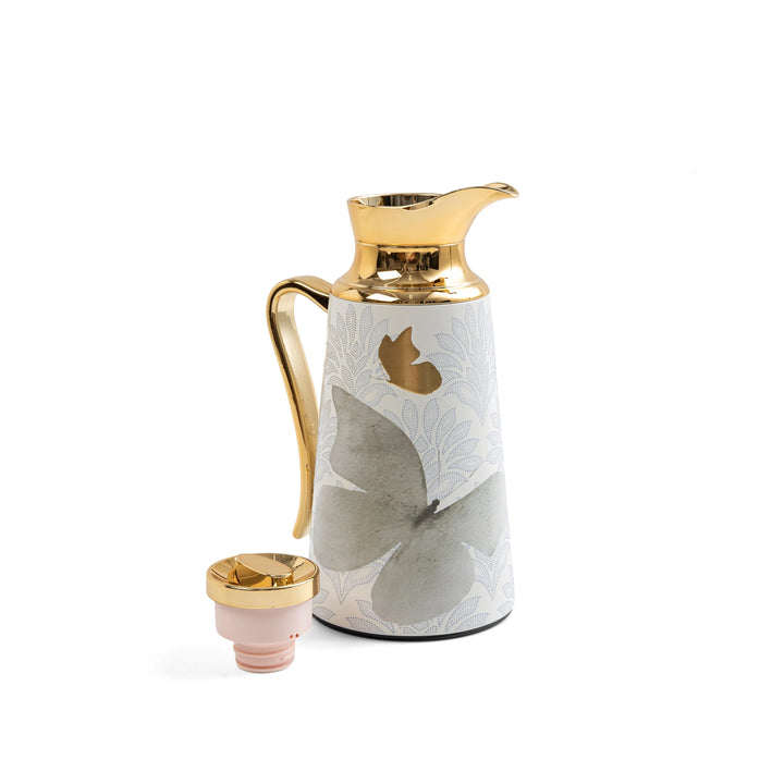 Ceramic carafe with gold accents on a white background