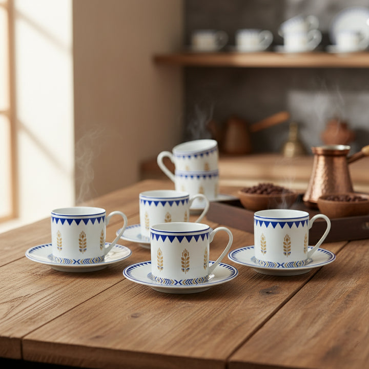 Set of ceramic coffee cups with saucers on a wooden table, with a kitchen background.