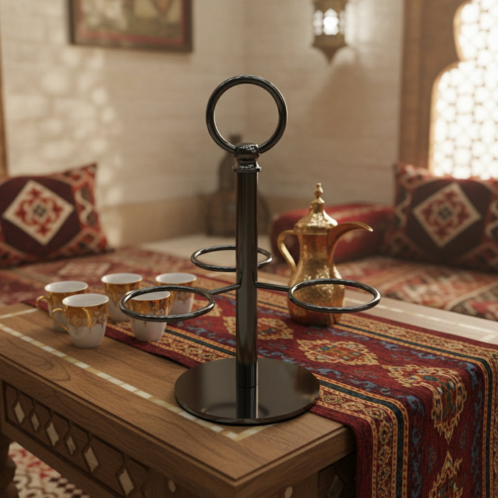 Decorative black metal stand with cups on a wooden table in a cozy room.