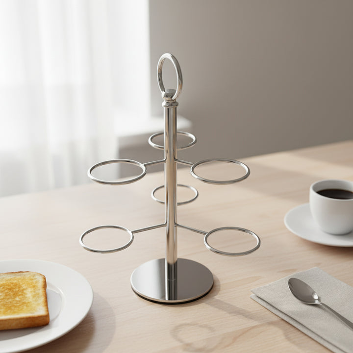 Silver tiered stand on a table with a cup of coffee, toast, and spoon.