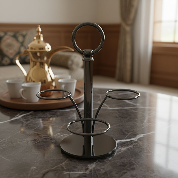 Metal cup stand on a marble surface with a gold teapot and white cups in the background.