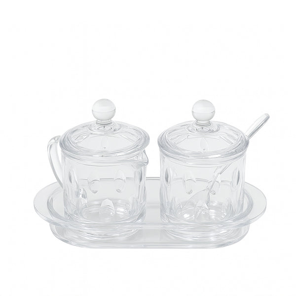 Clear glass condiment set with two jars and a tray on a white background