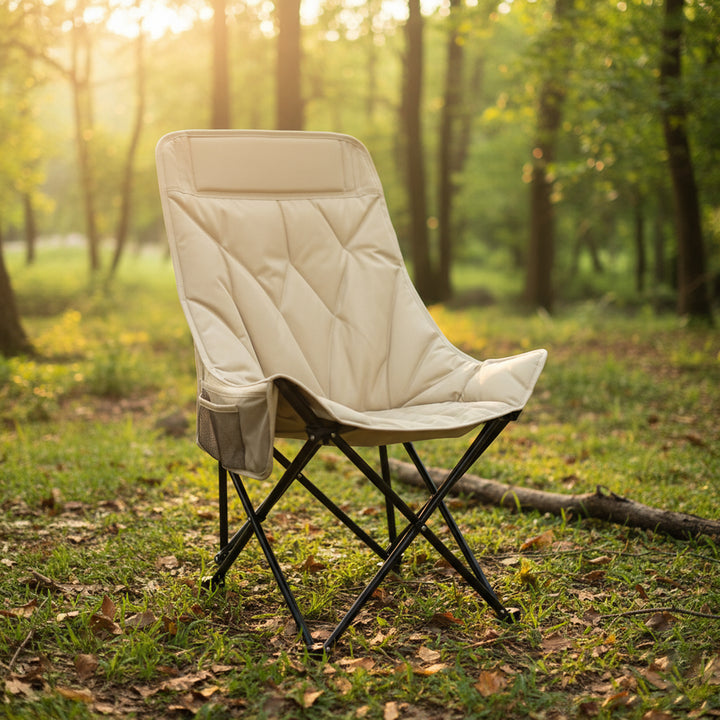 Beige camping chair in a forest setting with sunlight filtering through the trees.