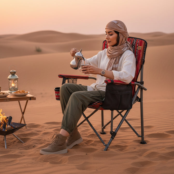 Person sitting in a desert setting, pouring tea from a teapot.