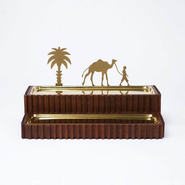 Decorative metal sculpture with camel, palm tree, and person on a white background