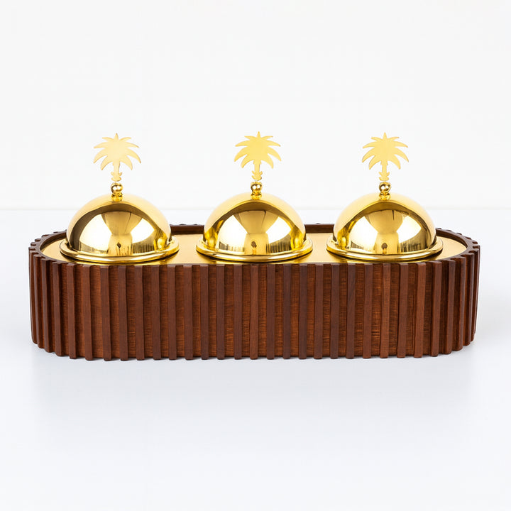 Decorative item with gold domes and palm tree accents on a wooden base.