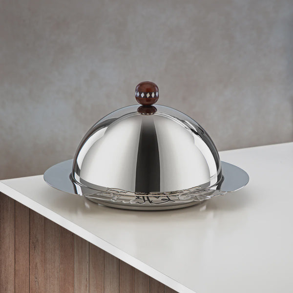 Stainless steel dome cover on a white surface with a neutral background