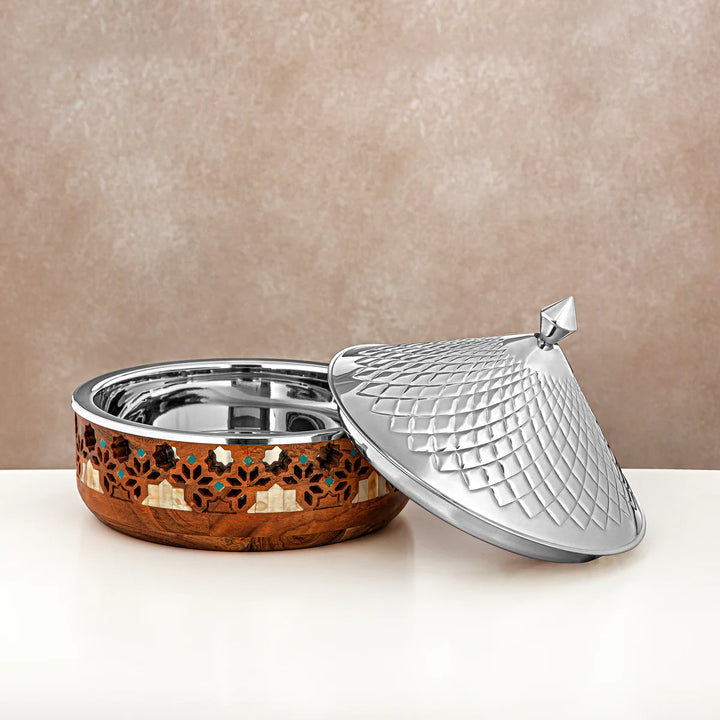 Decorative metal container with wooden base and silver lid on a beige background