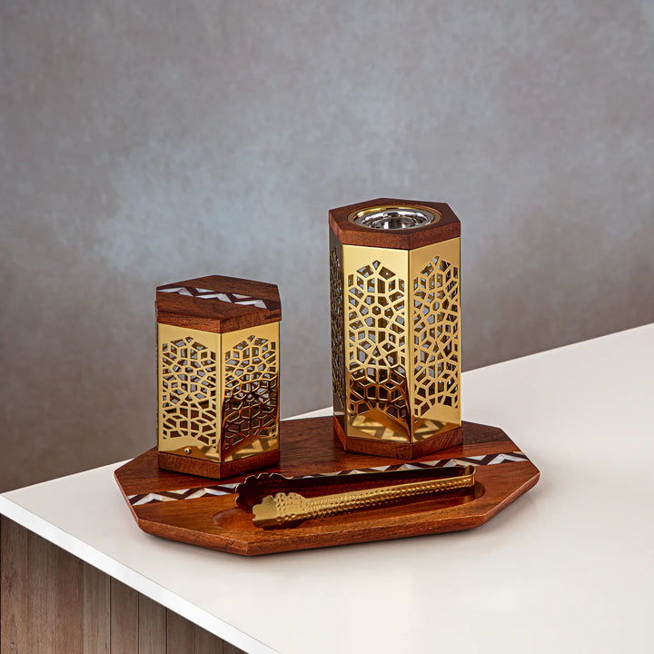 Decorative wooden lanterns with intricate patterns on a wooden tray against a gray background