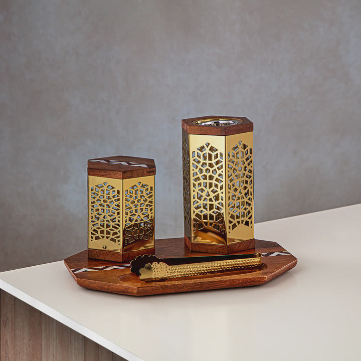 Decorative wooden and gold candle holders on a white surface with a gray background