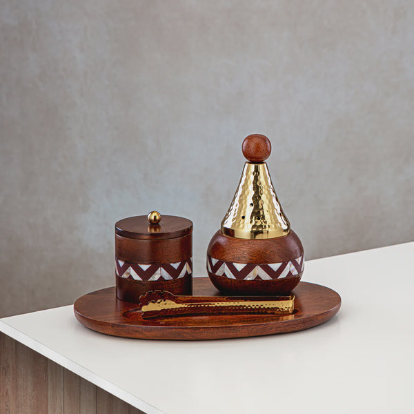 Wooden and brass decorative items on a tray against a neutral background