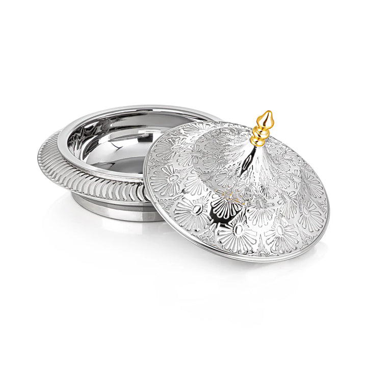 Decorative silver dish with intricate patterns on a white background