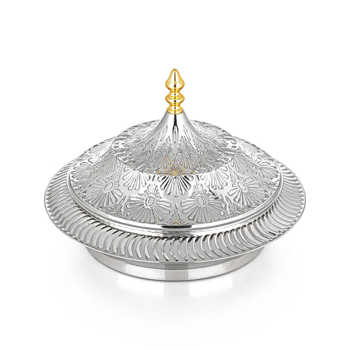 Decorative silver dish with intricate patterns on a white background